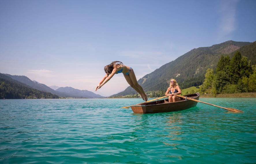 Mädchen springt aus dem Ruderboot in den Weissensee